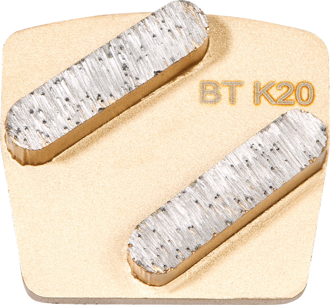 WOLFF_Dummy_68390_BT K20_2025-08 Een afbeelding van een metalen stuk met een rechthoekige vorm. Het oppervlak is voornamelijk goudkleurig met twee platte, metalen strips die horizontaal aan de bovenkant zijn geplaatst. De strips tonen een gestructureerd oppervlak dat slijtage aangeeft. De gravure 'BT K20' is zichtbaar in een contrasterende kleur, wat mogelijk een merk of productidentificatie aangeeft.