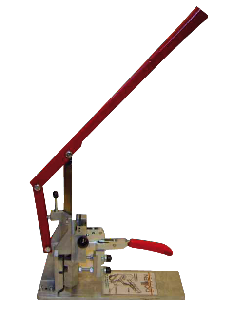 Een handmatige bankpers met een lange rode hendel en een klein rood handvat gemonteerd op een metalen basis, gebruikt voor het ponsen of persen van kleine onderdelen. De pers heeft een scharnierende arm, verstelbare onderdelen en een rechthoekige basisplaat met gedrukte instructies.